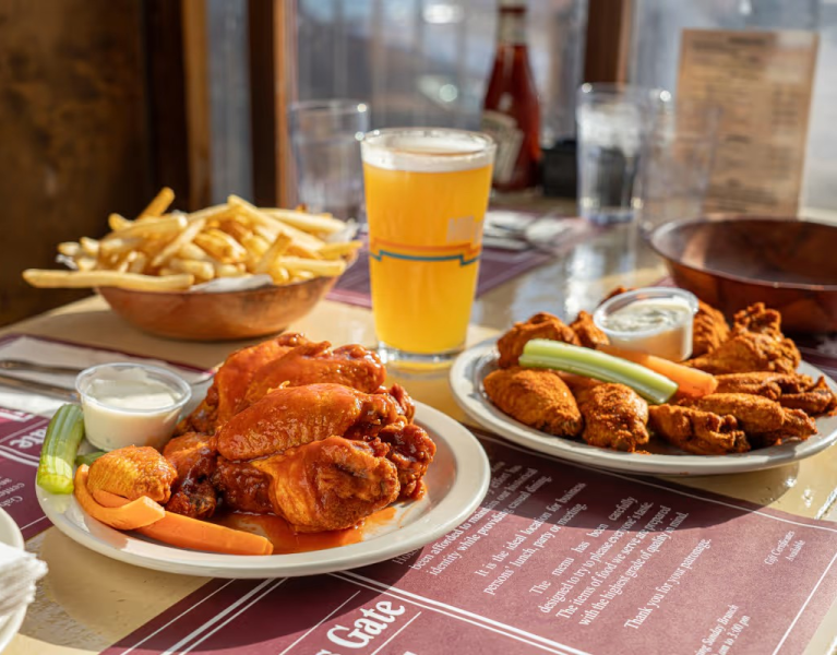 Gabriel's Gate, photo of table top with chicken wings, a beverage, and fries
